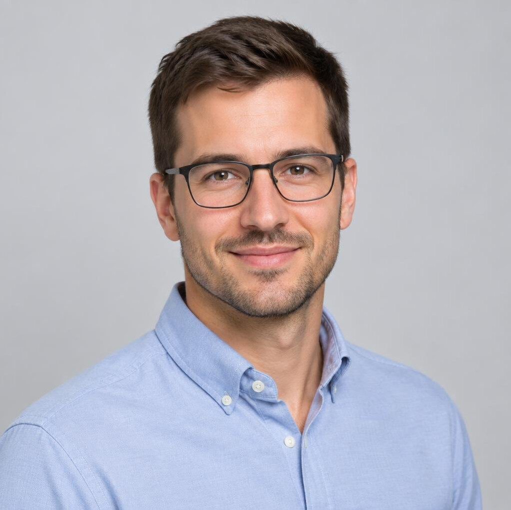 Studio portrait of a young European man with short hair and glasses