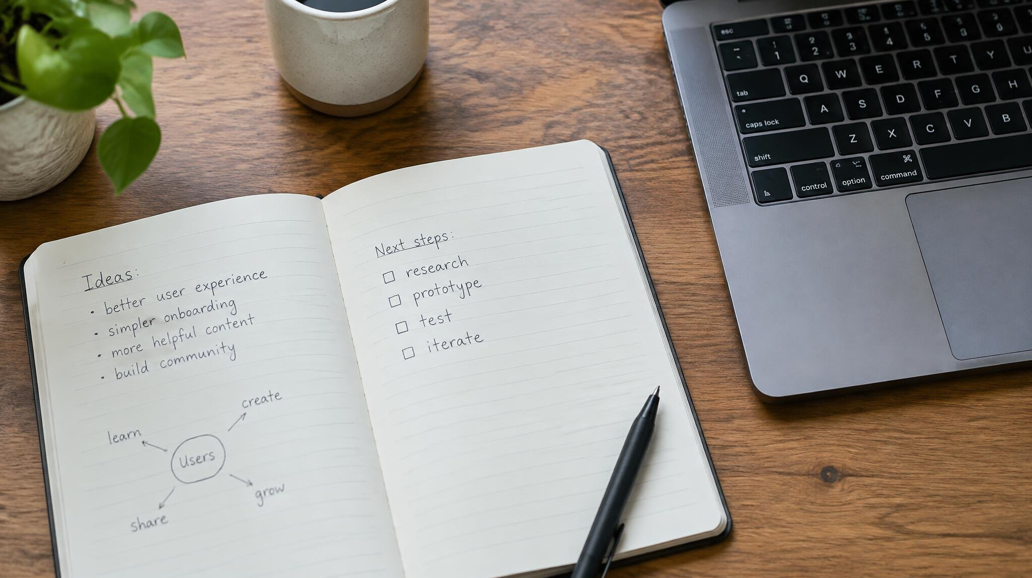 Open notebook with handwritten notes next to a laptop keyboard